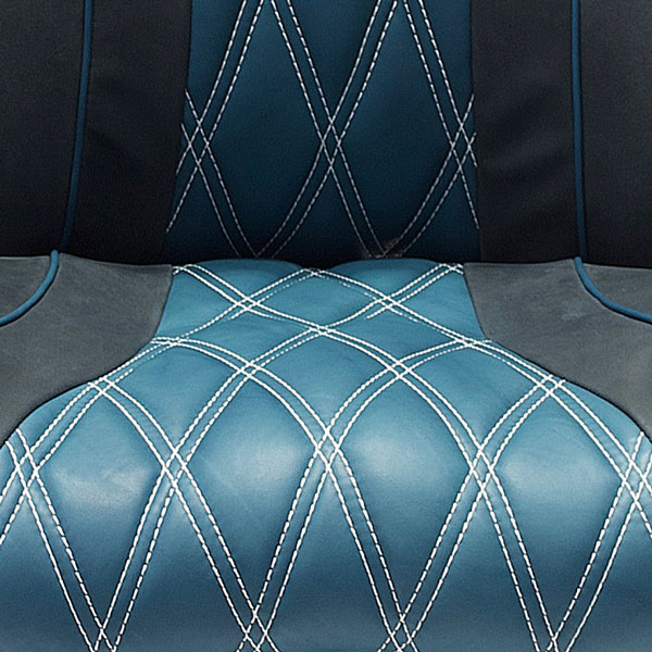 Close-up of a blue leather seat with white diamond-pattern stitching (QUILTING) and black side panels.