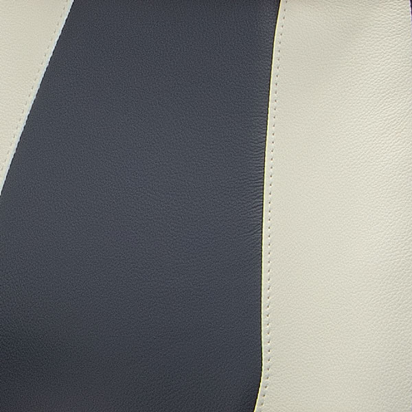 Close-up of two-tone upholstery with dark grey and cream panels.
