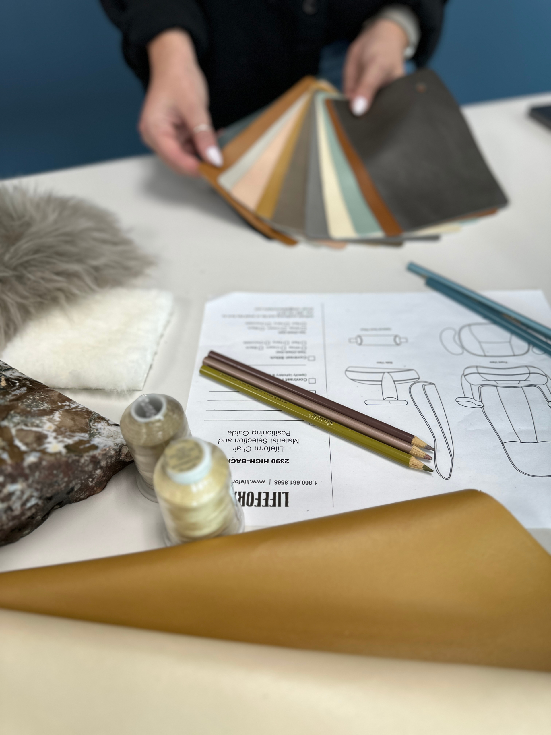 Designer reviews fabric swatches, materials, and sketches during the Lifeform Chair design process.