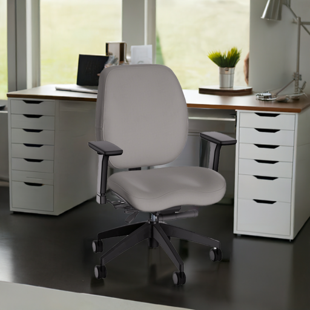 Grey ergonomic office chair with adjustable armrests and casters positioned at white desk with drawers in bright home office workspace.