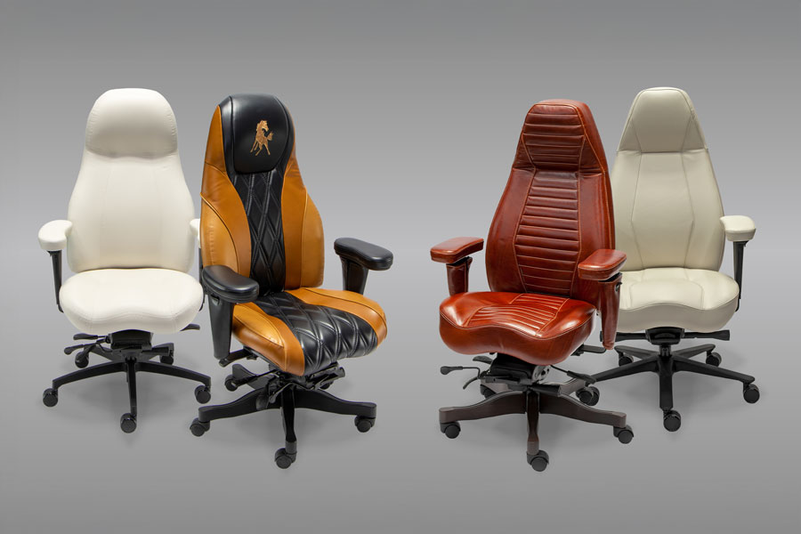 Four Lifeform high back office chairs in white, two tone brown and black, red brown, and cream leather arranged side by side.